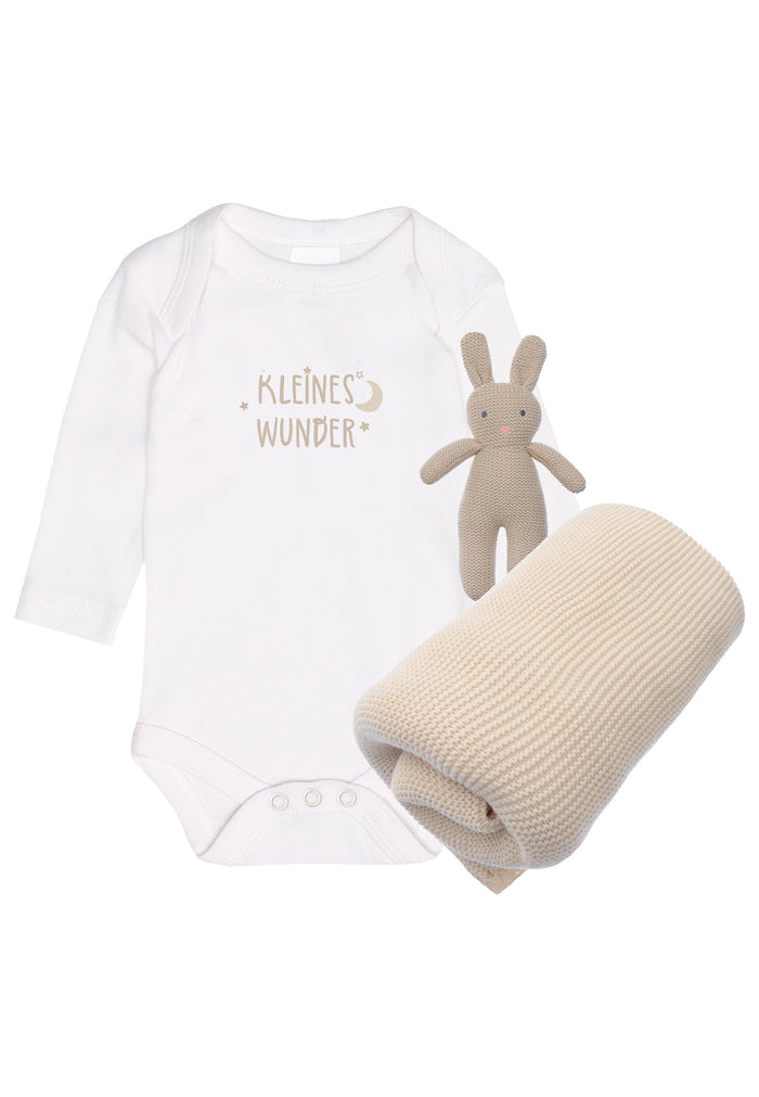 3 teiliges Geschenkset mit Amineckbody in weiß mit "kleines Wunder" Aufdruck, einem kleinen Strickhasen mit integrierter Rassel und einer wunderschönen Strickdecke in beige.