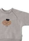Detailansicht des grau melangen Sweatshirts mit Raglanärmeln. Auf der Vorderseite ist ein Franzbrötchen und das Wording "moin" aufgedruckt.