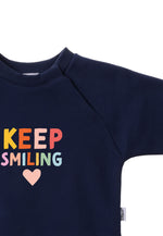 Detailansicht des bunten "keep smiling" Prints in hellen Farben.