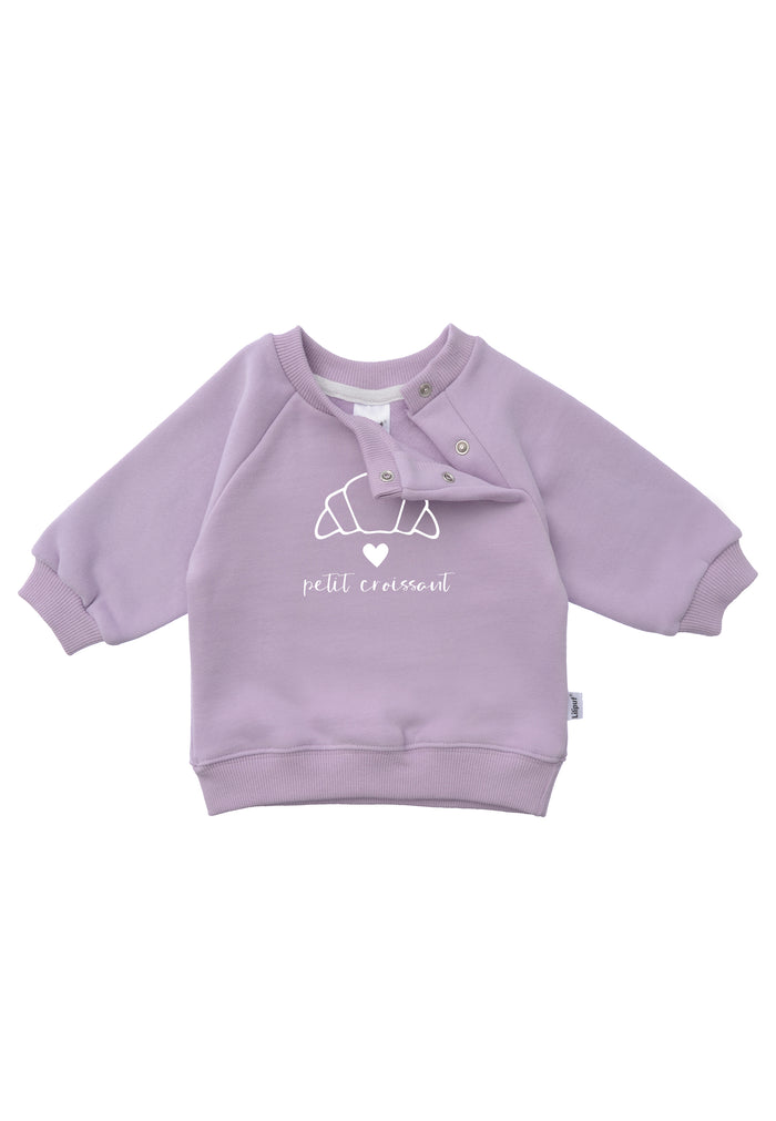 Detailfoto versteckte Druckknöpfe Sweatshirt in flieder mit Outline Print eines Croissants einem weißen Herz und dem Schriftzug petit croissant 