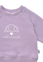 Detailfoto Druck Sweatshirt in flieder mit Outline Print eines Croissants einem weißen Herz und dem Schriftzug petit croissant 
