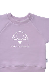 DetailfotoDruck Sweatshirt in flieder mit Outline Print eines Croissants einem weißen Herz und dem Schriftzug petit croissant 