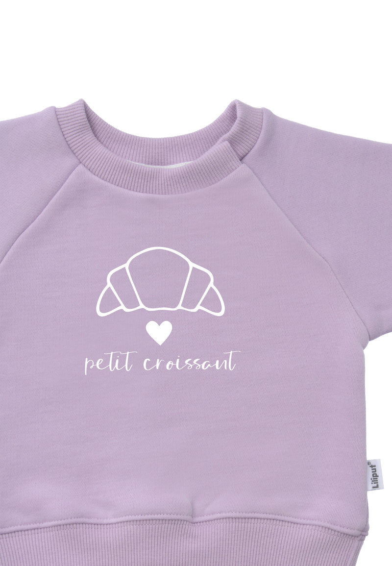 DetailfotoDruck Sweatshirt in flieder mit Outline Print eines Croissants einem weißen Herz und dem Schriftzug petit croissant 