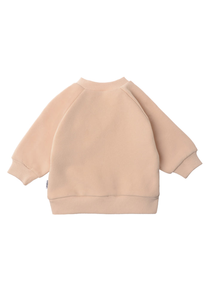 Die schlichte beige Rückseite des cozy Sweaters für Kinder.
