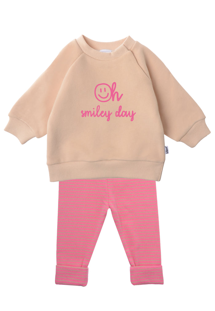 2-teiliges Baby Set mit beigem Sweatshirt mit pinkem „Oh smiley day“-Print und pink-rosa gestreifter Leggings, flach auf weißem Hintergrund