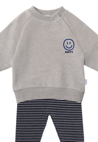2-teiliges Baby Set mit hellgrauem Sweatshirt mit „HAPPY“-Smiley-Print und dunkelblau-weiß gestreifter Leggings, flach auf weißem Hintergrund
