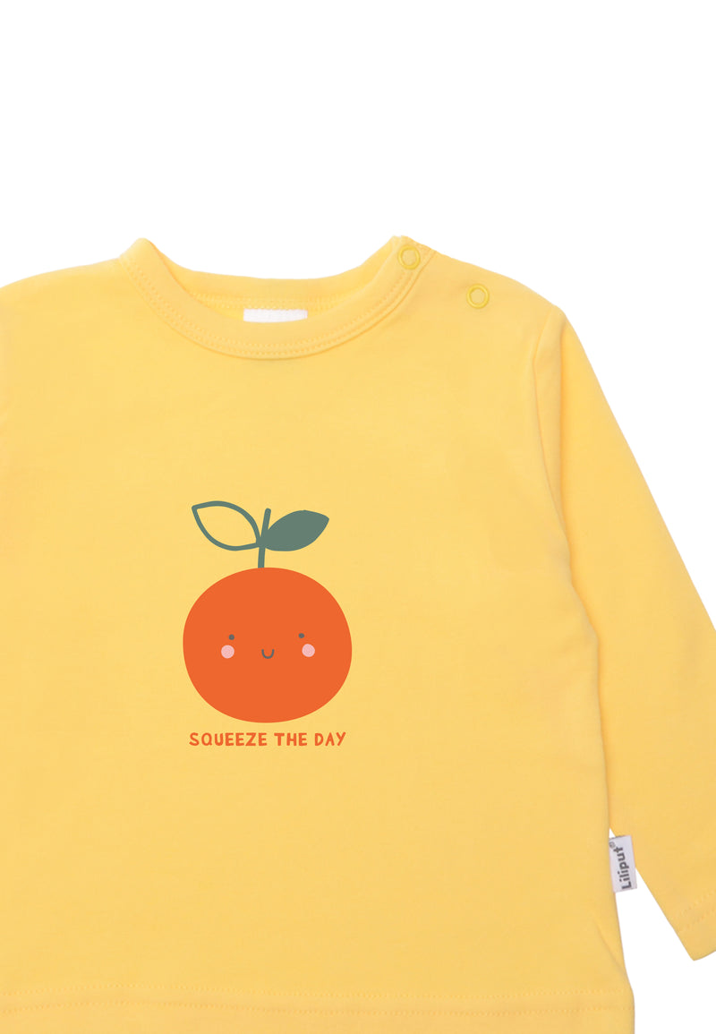 Detailansicht des fröhlich, buntem Shirt mit langen Ärmeln und frechen Print "squeeze the day", das eine grinsende Orange zeigt.