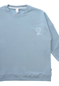 Detailansicht des hellblauen Sweaters mit grauem Motiv "when in doubt dance it out".