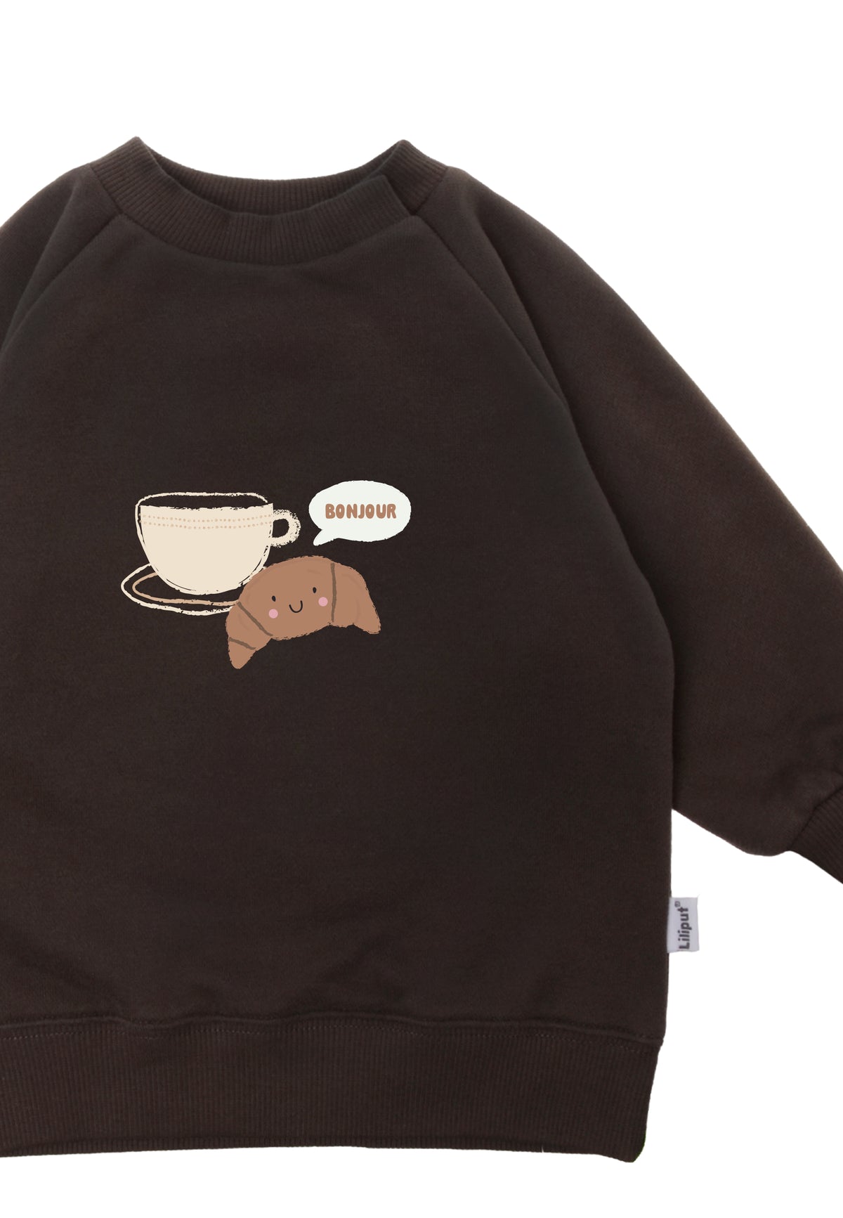 Detailansicht des braunen Sweatshirts mit Aufdruck Bonjour, einer Tasse und einem süßen, kleinen Croissant.
