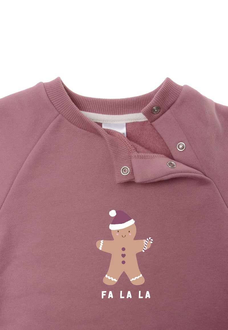 Weitere Detailansicht des weichen Sweaters in rosé mit weihnachtlichem Lebkuchen Aufdruck und versteckten Druckknöpfen am Halsausschnitt.