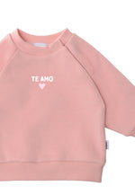 Detailansicht des rosanen Sweaters mit kleinem Te Amo Aufdruck in weiß und rosa.