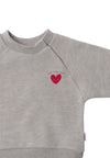 Detailansicht des grauen Sweatshirt mit rotem Herz als Aufdruck.