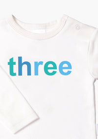 Kinder-Langarmshirt in ecru mit "three" in blau
