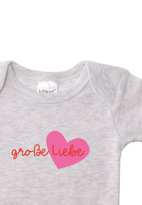 Detailaufnahme Kurzarmbody in grau mit Wording "große Liebe" in rot und pinkem Herz.