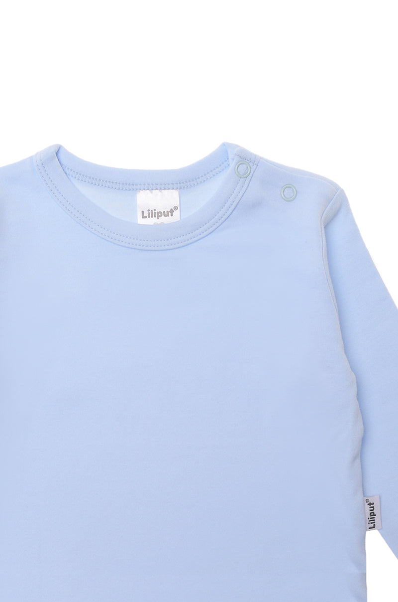 Detailansicht Langarmshirt in hellblau mit 2 Druckknöpfen auf der Schulter.