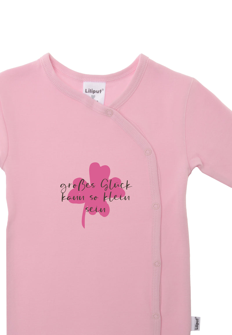 Detailaufnahme des rosa Overalls mit Print "Glück kann so klein klein".