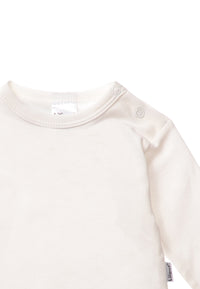 Detailaufnahme Langarmshirt in ecru mit praktischem Druckknopf auf der Schulter für ein leichtes An- und Ausziehen.