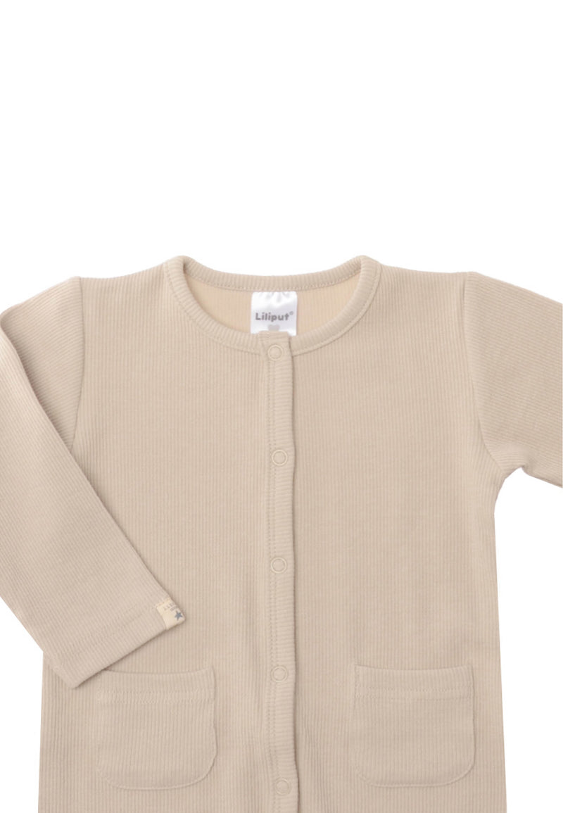 Detailaufnahme des Overalls in beige mit Patch am Ärmel "little one".